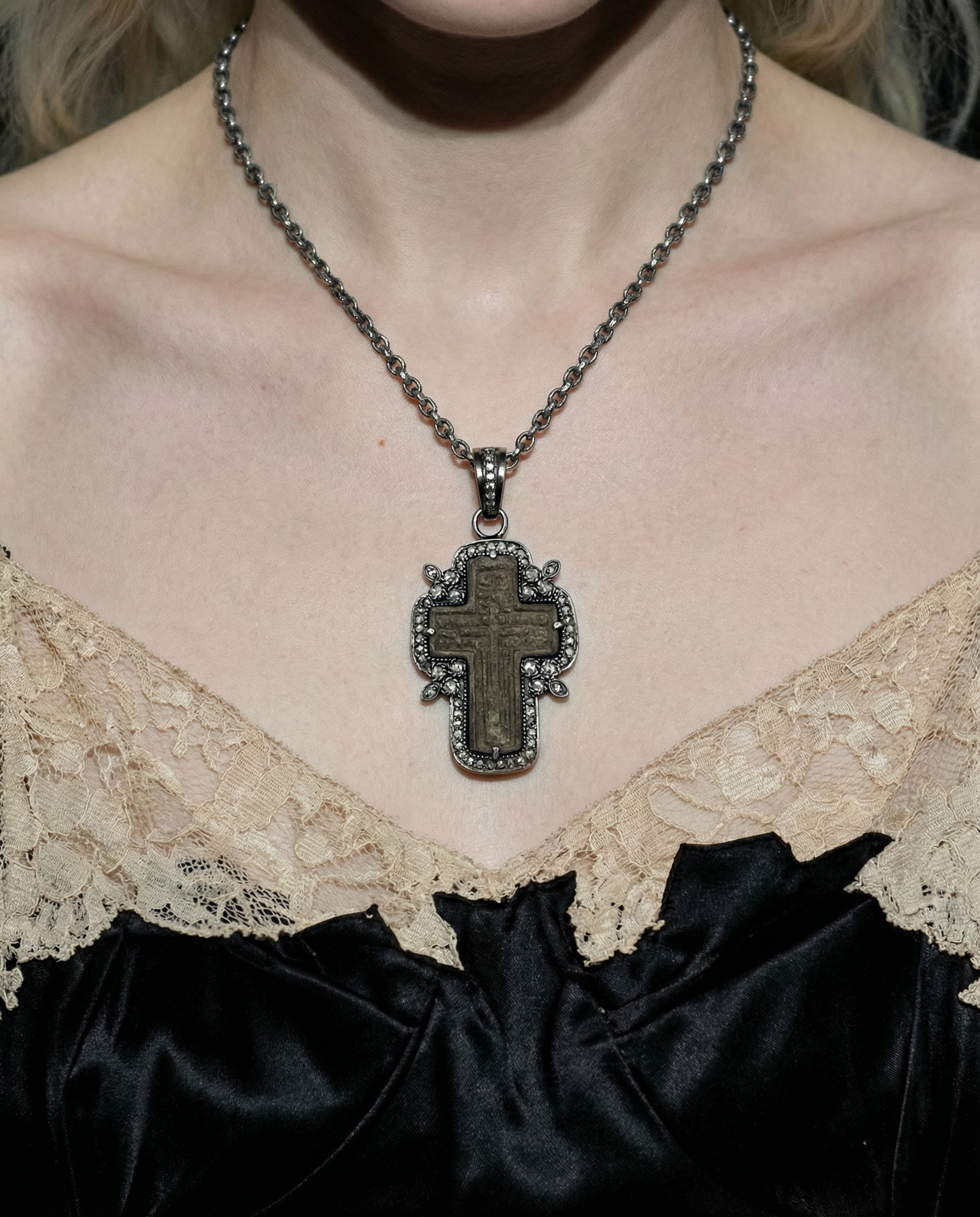 17th–18th century Russian Old Believers cross with deep aged patina and heavily worn surface. Faint traces of a Cyrillic inscription remain on the reverse. Framed in oxidized sterling silver with 66 natural diamonds wearing by person in black silk tank.