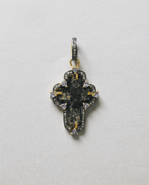 Close-up of authentic 17th–18th century sand-cast copper Old Believers Christian cross with historical patina and engravings, set in 24kt gold-plated sterling silver with diamond and tanzanite accents on a vintage paper. 