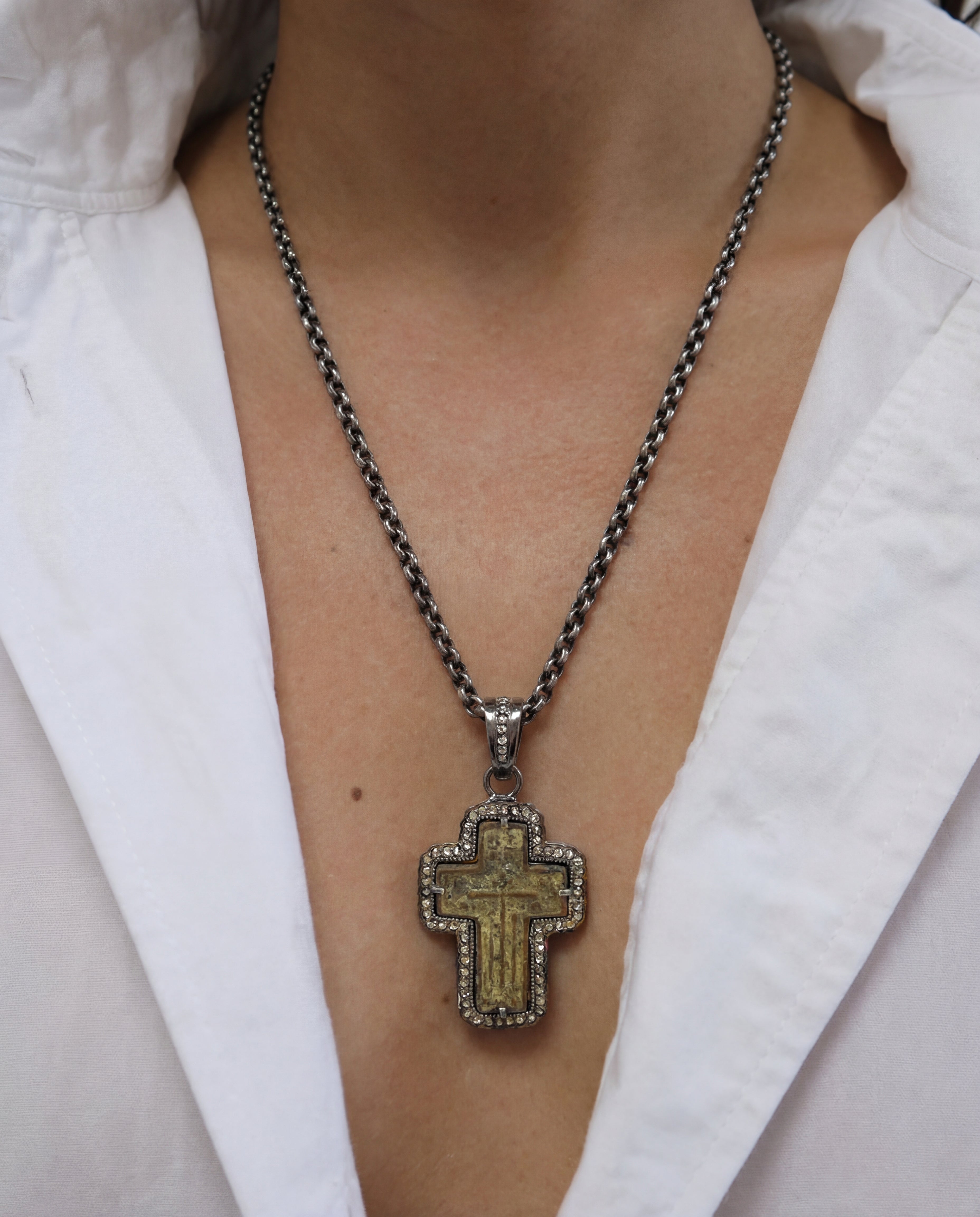 Antique 17th–18th century Russian Orthodox Old Believers cross in oxidized sterling silver frame with aged copper patina and 0.73ct natural diamonds (69 stones) showcasing on person on white tank.
