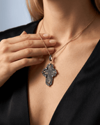 Antique 17th–18th century Russian Orthodox Old Believers cross in 24kt gold-plated silver frame with aged copper patina, 0.6ct natural diamonds and 1.04ct violet tanzanite worn by a model against a neutral background