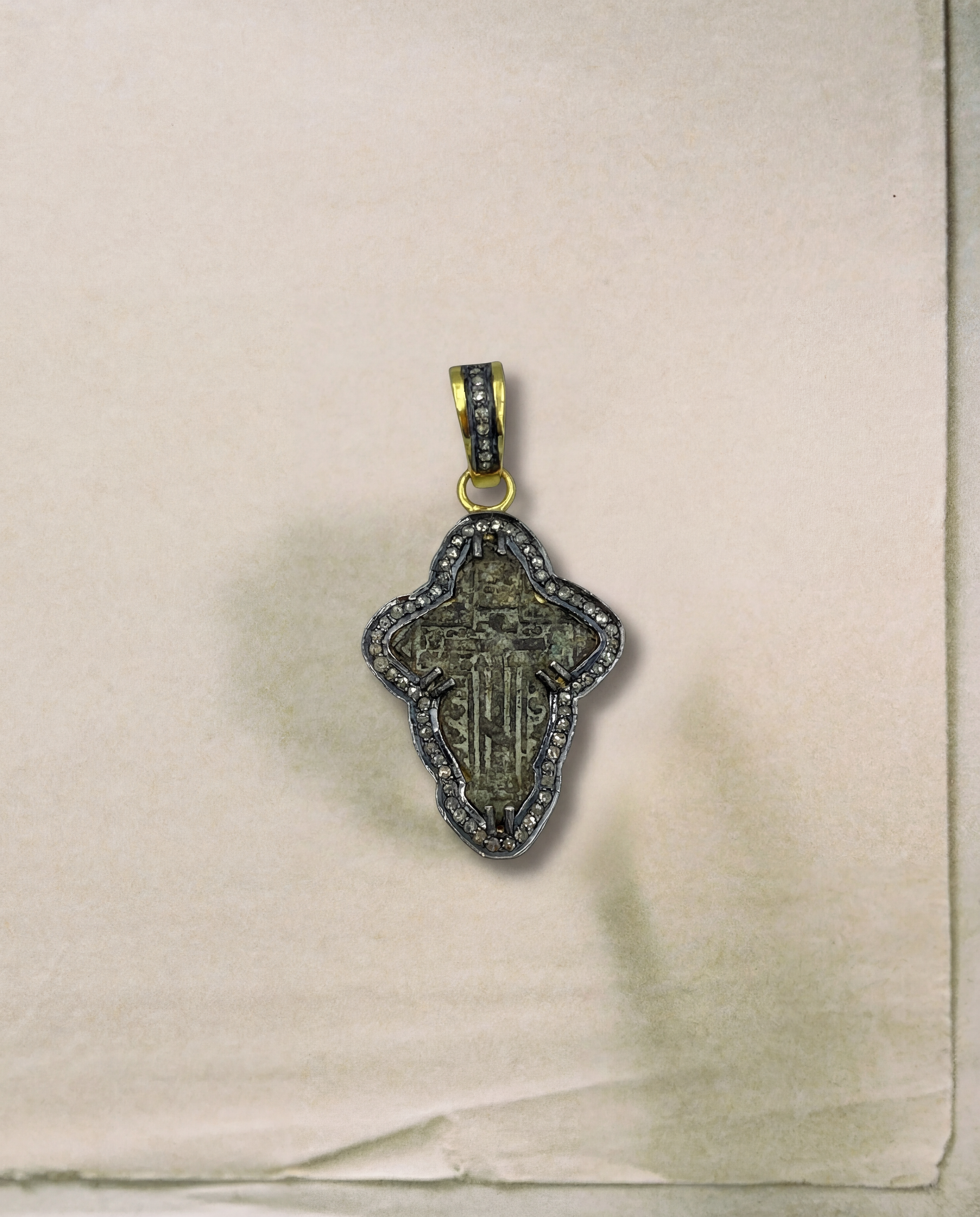 Close-up of authentic late 17th–18th century sand-cast copper Old Believers cross with aged patina, set in 24kt gold-plated sterling silver with natural diamond accents